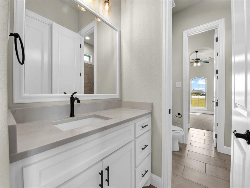 Bathroom featuring tile patterned flooring, ceiling fan, toilet, and vanity