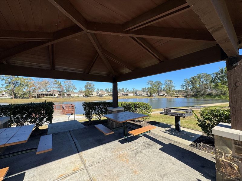 Charming covered patio area with picnic tables and a grill, overlooking a serene pond and surrounded by lush greenery—perfect for outdoor gatherings and relaxation. Charming covered patio area with picnic tables and a grill, overlooking a serene pond and surrounded by lush greenery—perfect for outdoor gatherings and relaxation.