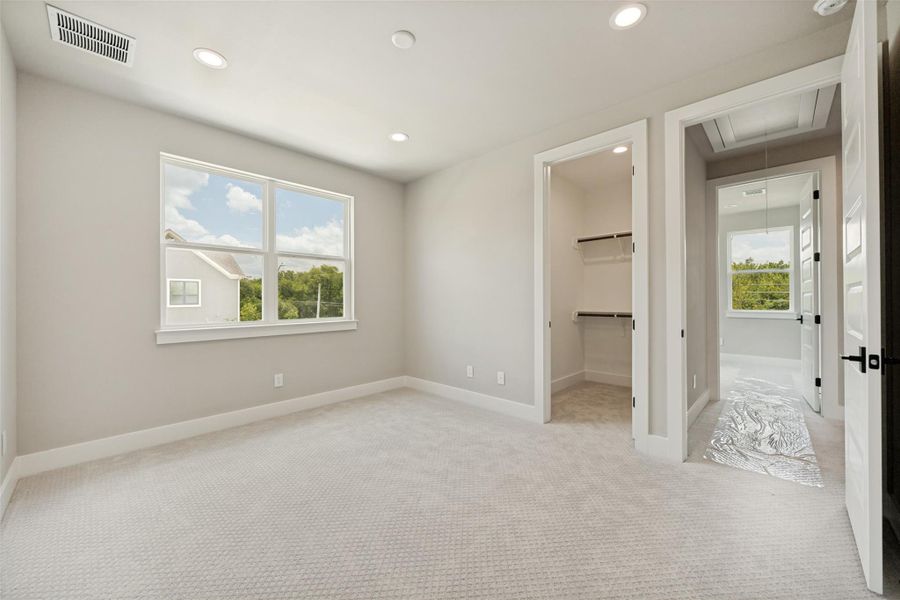 A quiet secondary bedroom offers ample natural light and a generous walk-in closet. A quiet secondary bedroom offers ample natural light and a generous walk-in closet.
