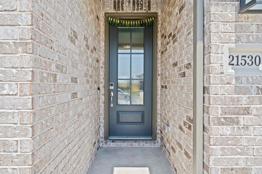 The front entry detail highlights the stone exterior, covered porch approach, and modern front door. It creates a clean arrival moment before stepping inside. The front entry detail highlights the stone exterior, covered porch approach, and modern front door. It creates a clean arrival moment before stepping inside.