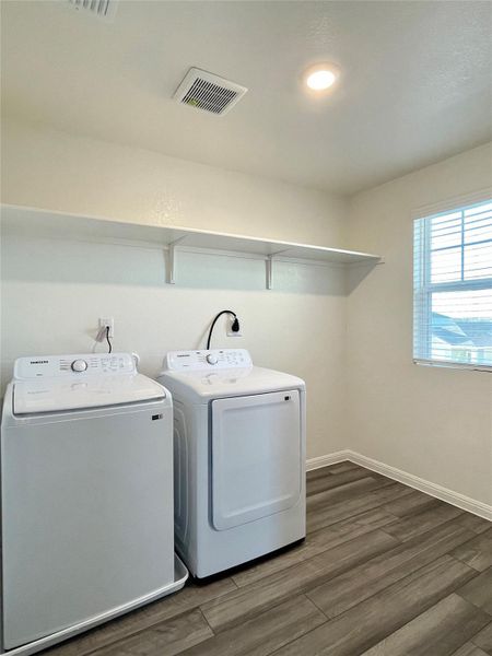 Washroom featuring dark wood finished floors and washer and clothes dryer