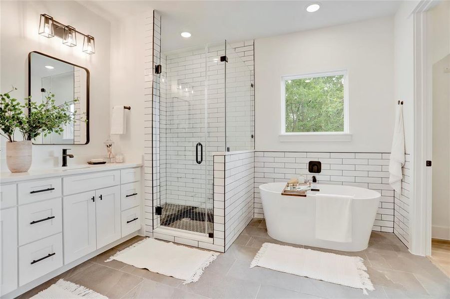 The primary bath has a soaking tub and standing shower with subway tile surround.