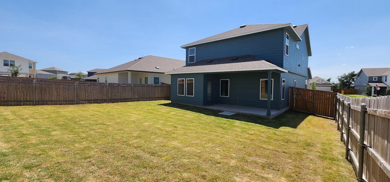 A spacious backyard awaits, featuring a covered patio for outdoor enjoyment. A spacious backyard awaits, featuring a covered patio for outdoor enjoyment.
