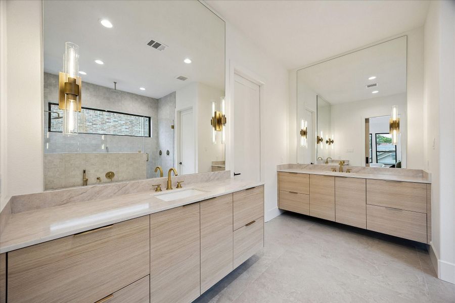 Primary bath – features Taj Mahal quartz countertops and designer sconces. Primary bath – features Taj Mahal quartz countertops and designer sconces.