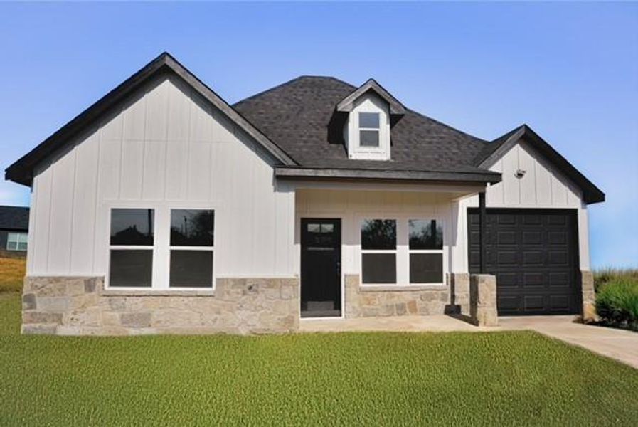 View of front of house with a garage and a front lawn