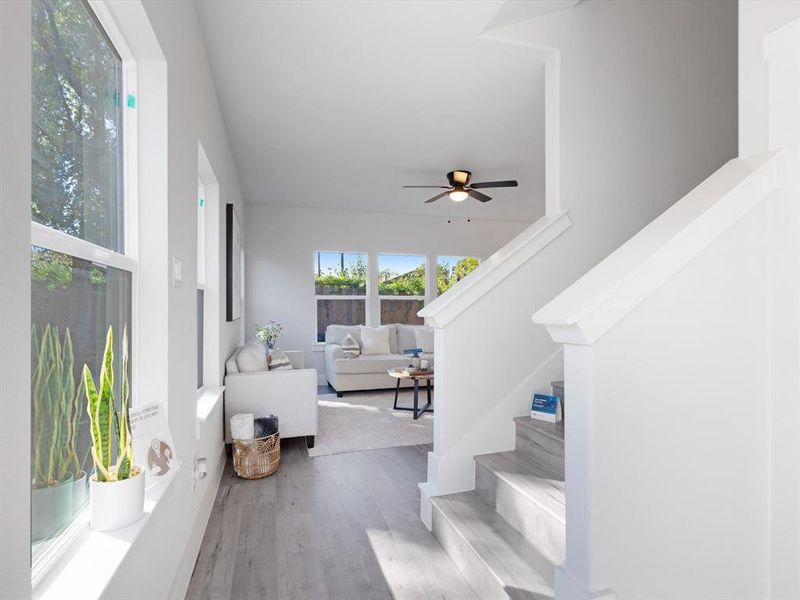 Stairs with hardwood / wood-style floors and ceiling fan