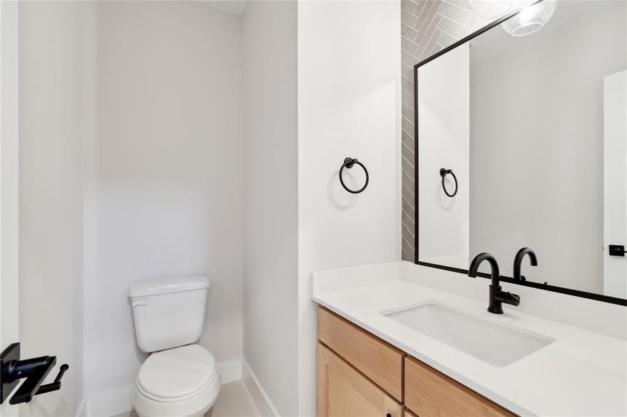 The powder is accompanied with chevron tile as it surrounds a framed mirror that matched the matte fixtures.