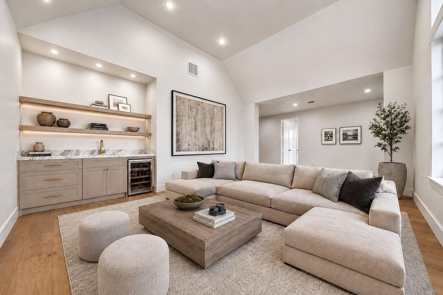 Second floor game rom with drink fridge, wet bar, custom cabinetry and vaulted ceilings
