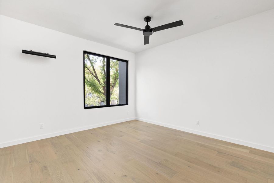 Empty room featuring light wood-style floors and a ceiling fan