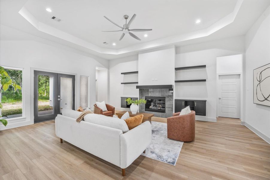 Bright and spacious living room with modern finishes, featuring a fireplace, built-in shelves, and large windows. The open layout and neutral tones create a welcoming atmosphere, ideal for relaxation and entertaining. Bright and spacious living room with modern finishes, featuring a fireplace, built-in shelves, and large windows. The open layout and neutral tones create a welcoming atmosphere, ideal for relaxation and entertaining.