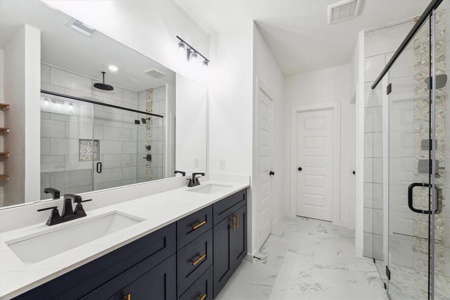 Experience luxury in the primary bath, which features a double vanity and a spacious walk-in shower. The modern design and high-quality finishes create a spa-like atmosphere, providing a perfect place to start or end your day in comfort and style.