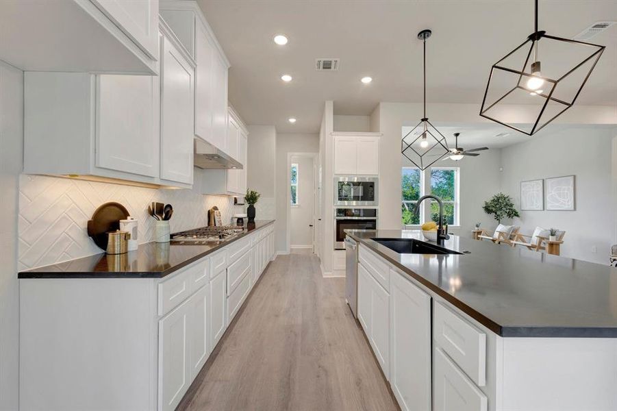 Contemporary kitchen featuring white cabinetry, dark countertops, and light wood-finish flooring