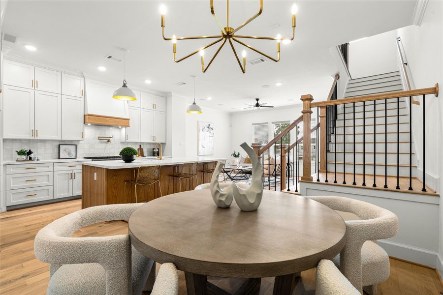 The adjacent dining area offers cozy seating, while the stylish staircase adds a touch of sophistication.