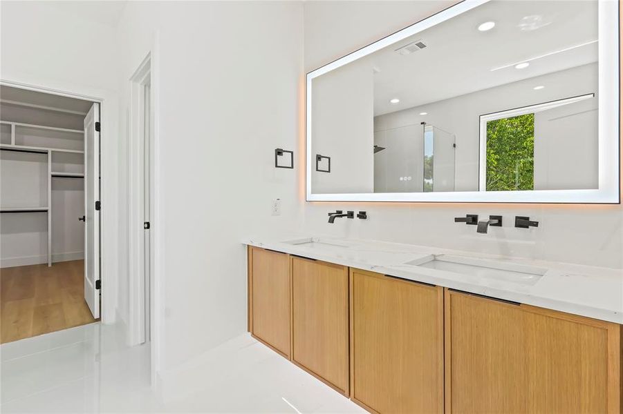 Full bathroom with double vanity, a stall shower, a walk in closet, recessed lighting, and light tile patterned flooring