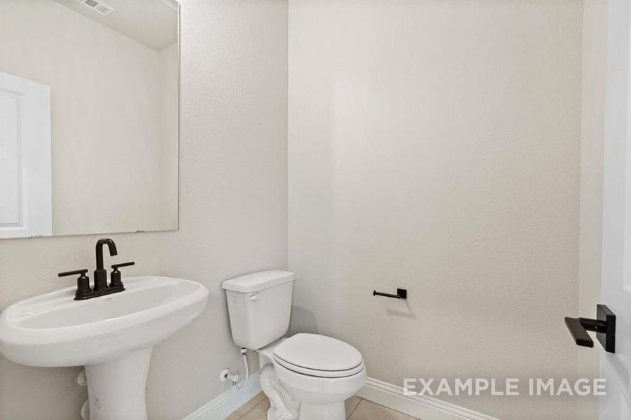 Bathroom with tile patterned flooring, toilet, and sink