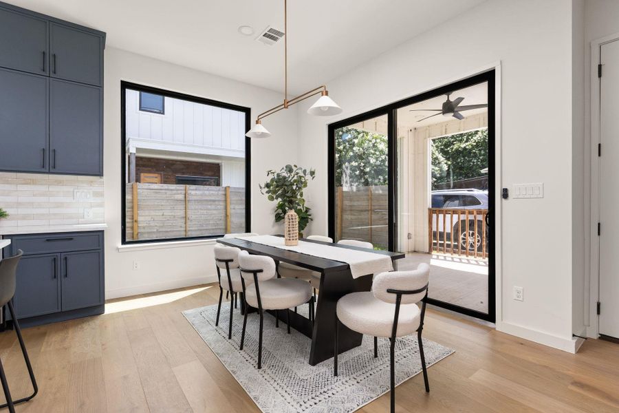 A refined dining space connects to an outdoor area through expansive glass sliding doors.