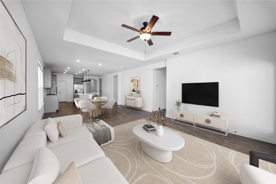 Living area featuring a raised ceiling, wood finished floors, crown molding, ceiling fan, and recessed lighting Living area featuring a raised ceiling, wood finished floors, crown molding, ceiling fan, and recessed lighting