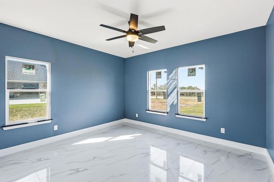 Spare room featuring marble finish flooring and ceiling fan