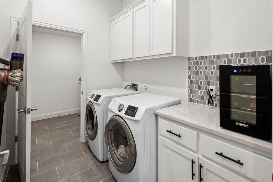 Laundry room with cabinet space, independent washer and dryer, and baseboards