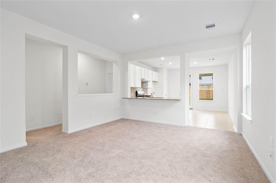 As you re-enter the great room from the hallway of bedrooms, the kitchen has an extended countertop for a breakfast bar!