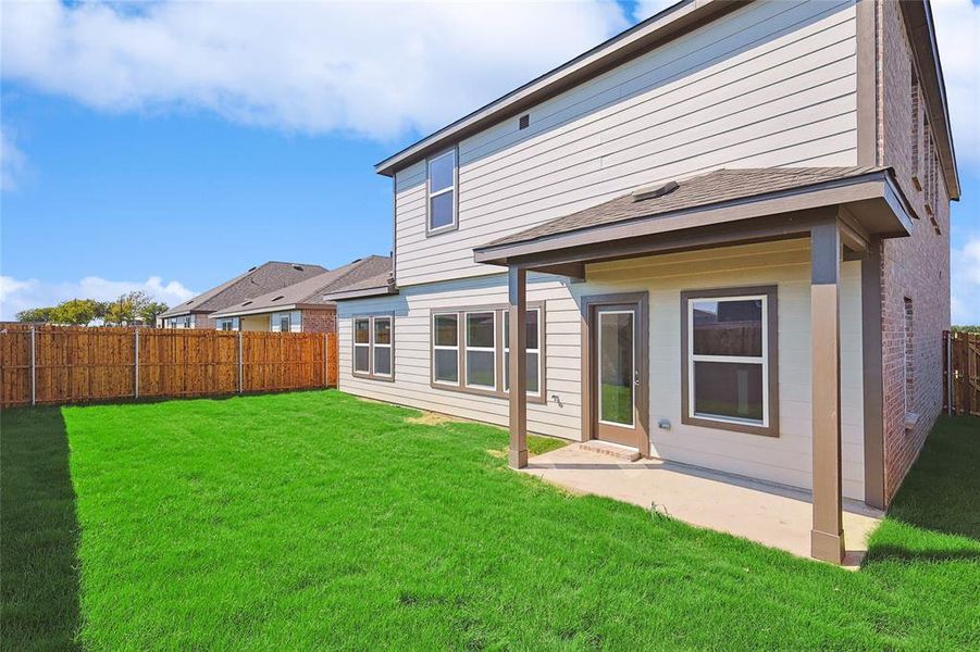 Rear view of property featuring a patio, a fenced backyard, and a shingled roof