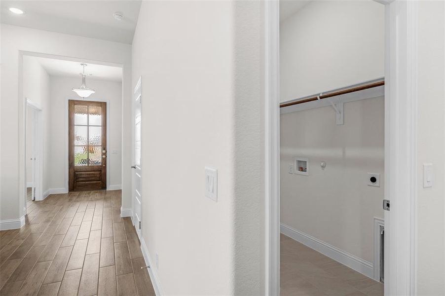 Laundry area with gas dryer hookup, light wood-type flooring, and electric dryer hookup Laundry area with gas dryer hookup, light wood-type flooring, and electric dryer hookup