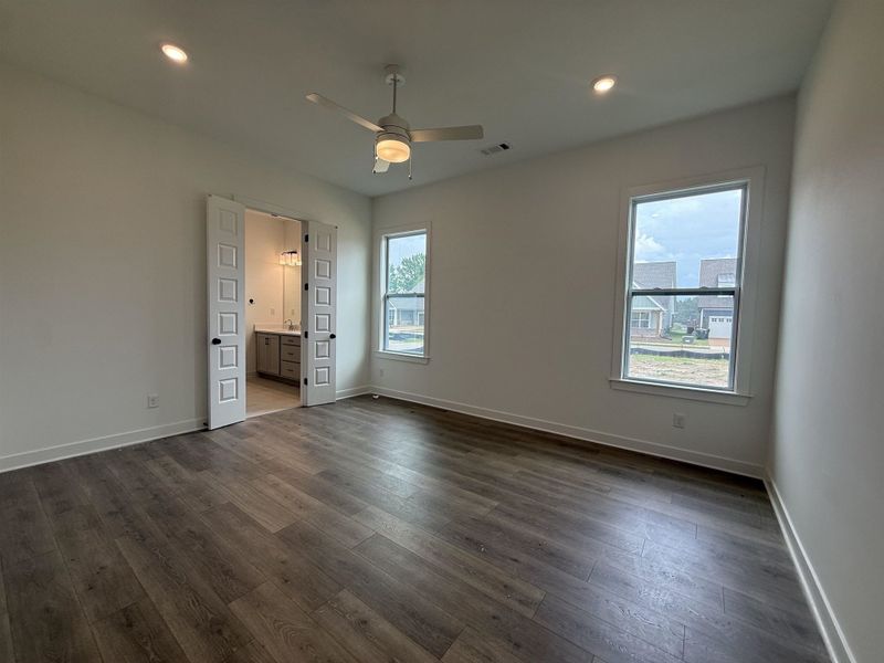 Spacious room featuring wood-finish flooring, recessed lighting, and a ceiling fan