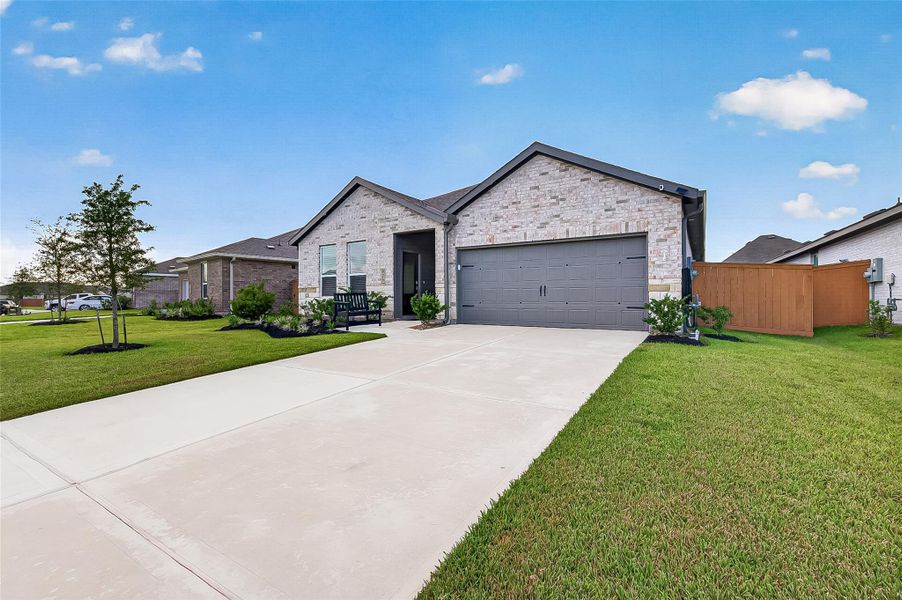 Front exterior featuring brick construction, an attached garage, and well-maintained landscaping. Front exterior featuring brick construction, an attached garage, and well-maintained landscaping.