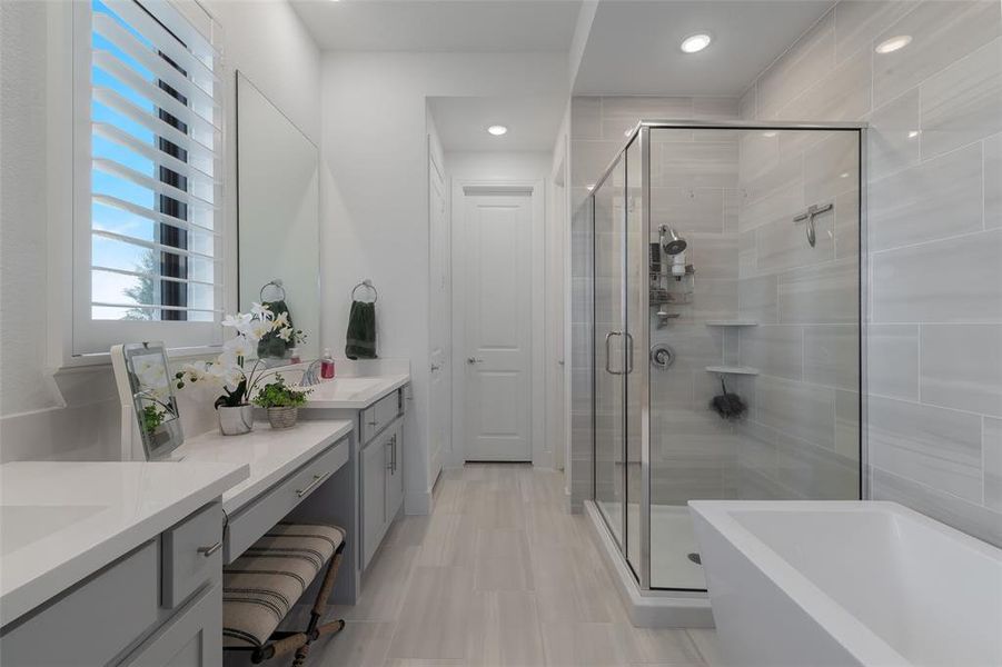 Full bath featuring a freestanding tub, a shower stall, and vanity