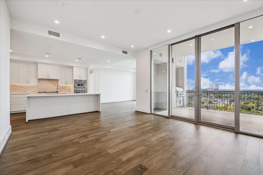 Open living space with expansive floor-to-ceiling windows, providing abundant natural light and sweeping views of the city. The spacious layout features clean architectural lines, recessed lighting, and direct access to a private balcony Open living space with expansive floor-to-ceiling windows, providing abundant natural light and sweeping views of the city. The spacious layout features clean architectural lines, recessed lighting, and direct access to a private balcony