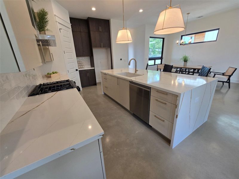 Kitchen with a sink, tasteful backsplash, modern cabinets, concrete floors, and dishwasher Kitchen with a sink, tasteful backsplash, modern cabinets, concrete floors, and dishwasher