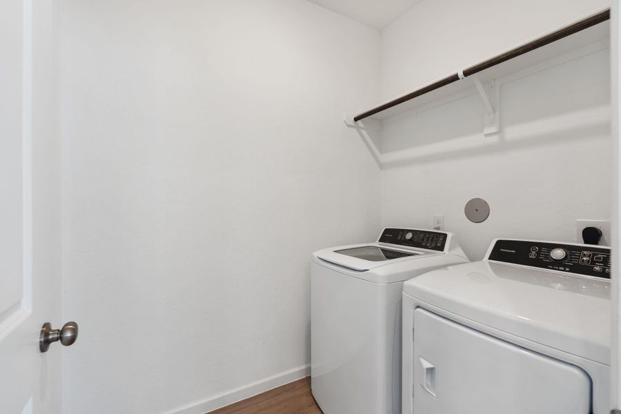 Laundry room is a great size, featuring built-in shelving and hanging rod.