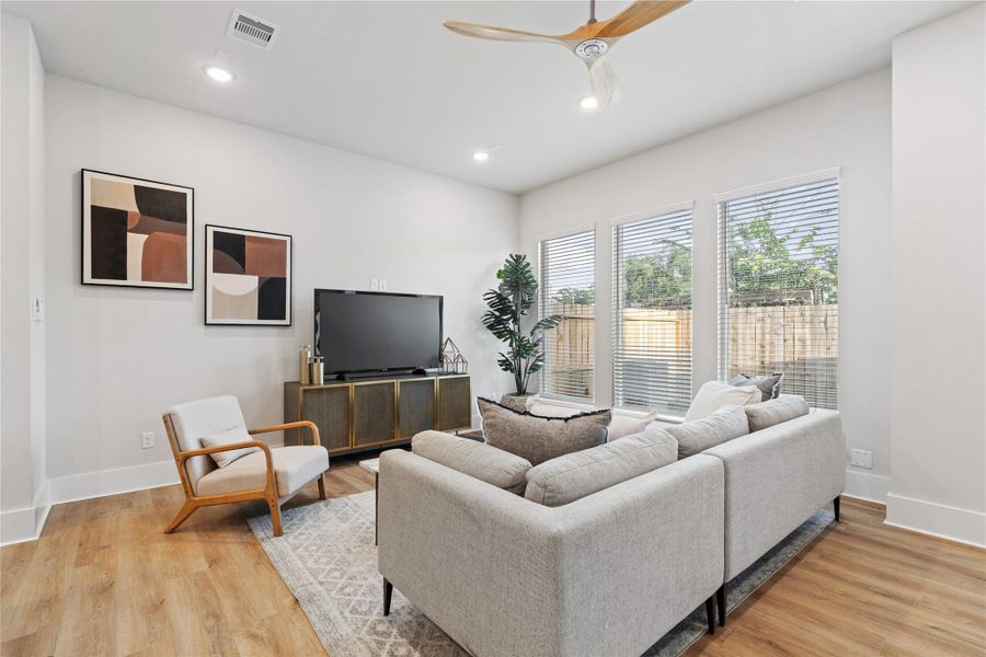 Natural light becomes a design feature here, with oversized picture windows illuminating the living space and enhancing its open, welcoming feel.