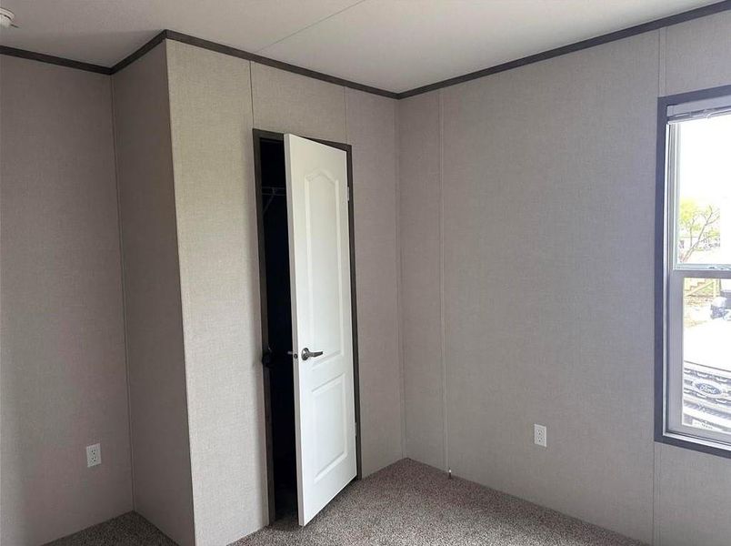 Empty room featuring light colored carpet and ornamental molding Empty room featuring light colored carpet and ornamental molding