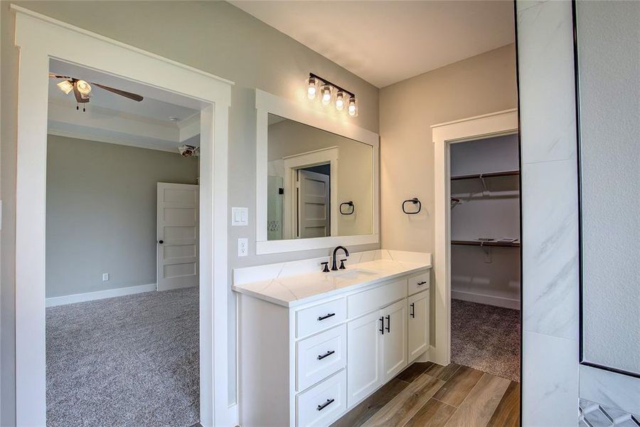 Bathroom with wood-type flooring, vanity, and ceiling fan Bathroom with wood-type flooring, vanity, and ceiling fan