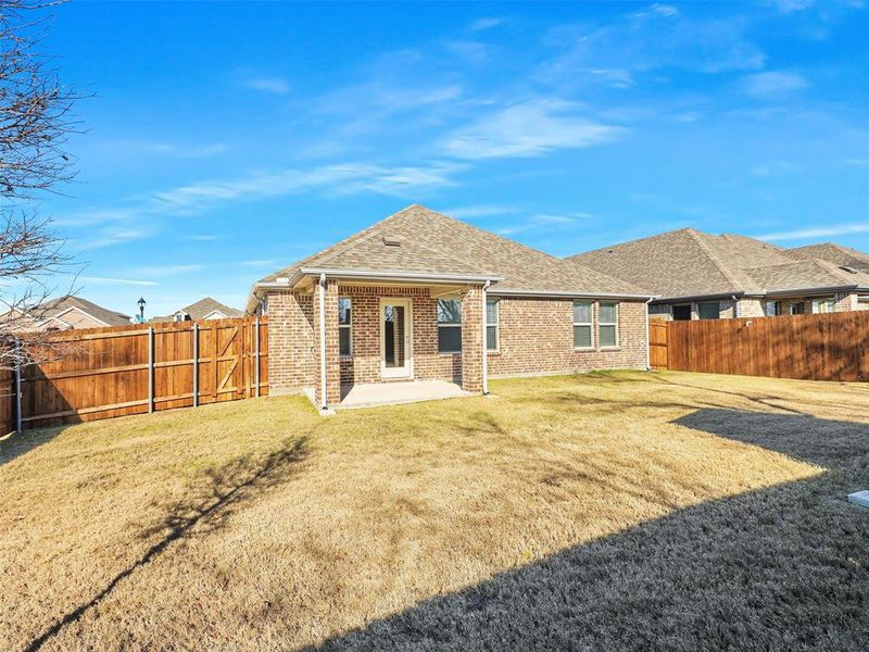 Rear view of house with a yard and a patio