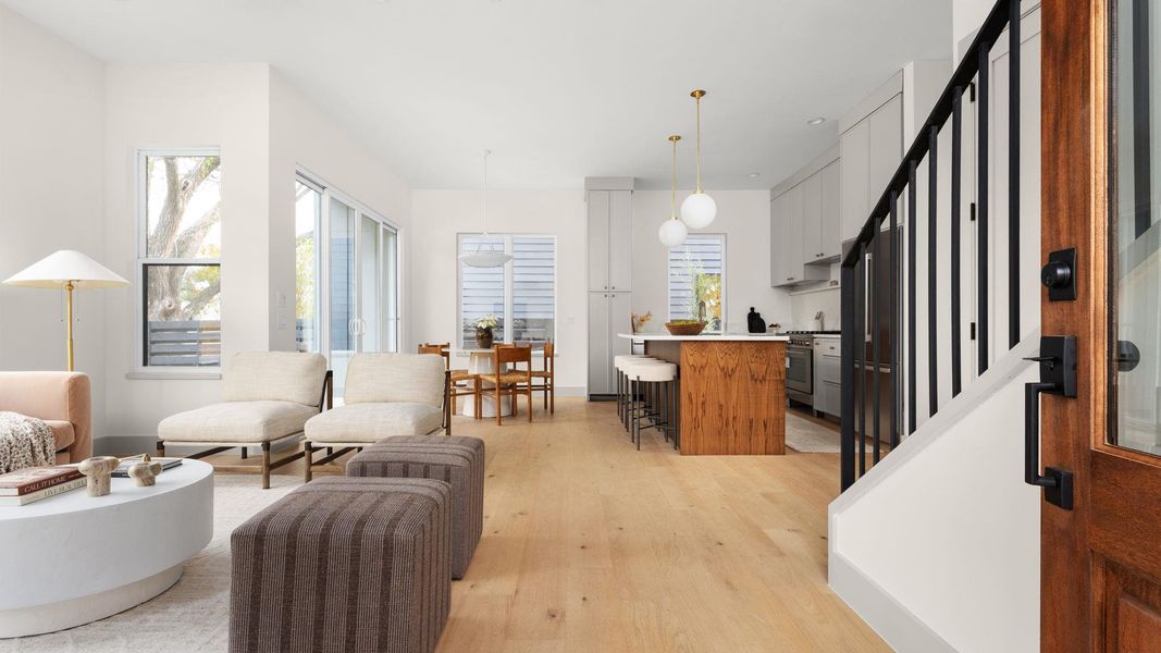 Living room featuring stairway, light wood-type flooring, and healthy amount of natural light