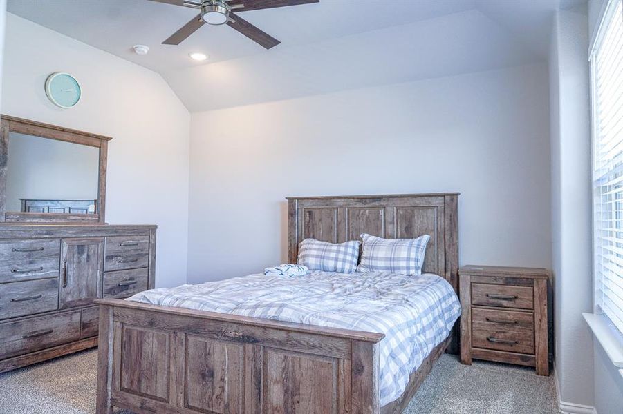 Bedroom with carpet flooring, a ceiling fan, lofted ceiling, and recessed lighting