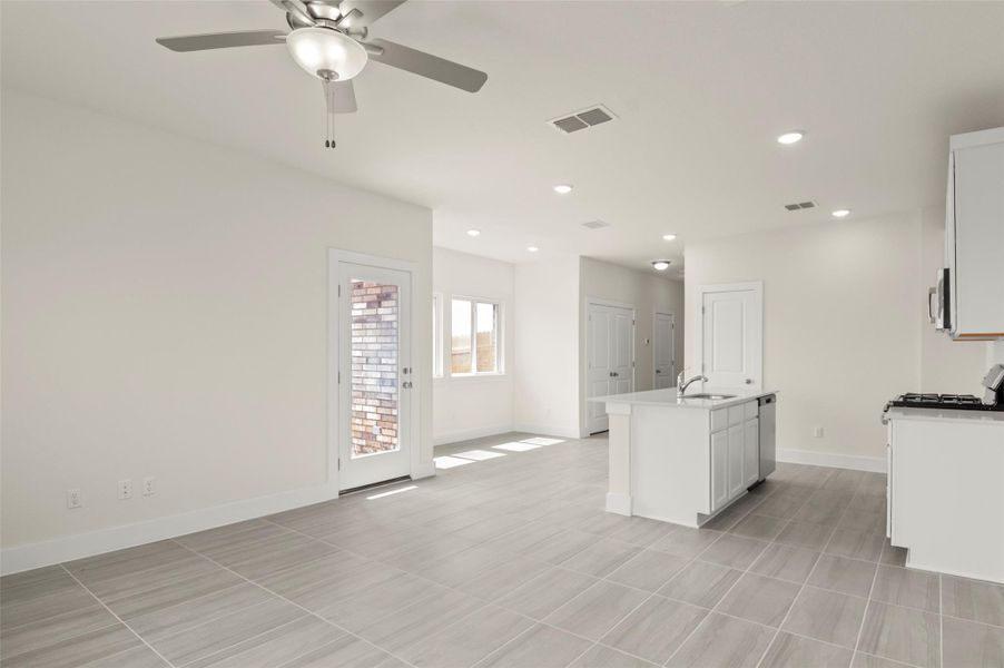 Kitchen with a sink, baseboards, ceiling fan, and visible vents