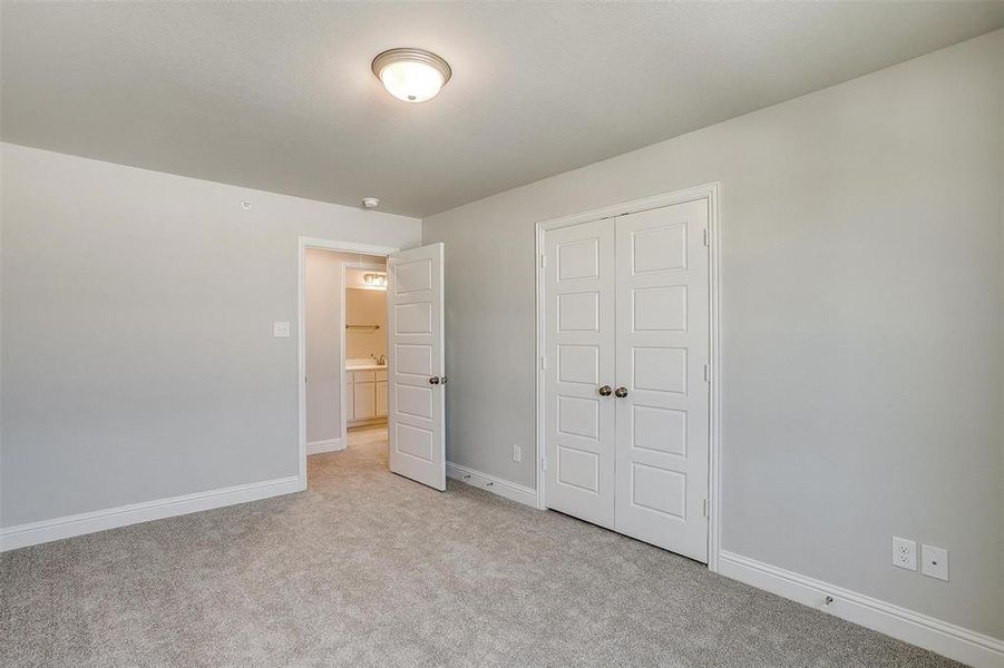 Unfurnished bedroom featuring light colored carpet and a closet