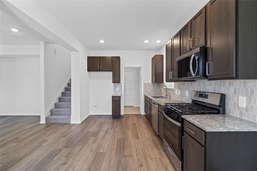 Additional view of the kitchen highlighting the granite countertops and backsplash. Additional view of the kitchen highlighting the granite countertops and backsplash.