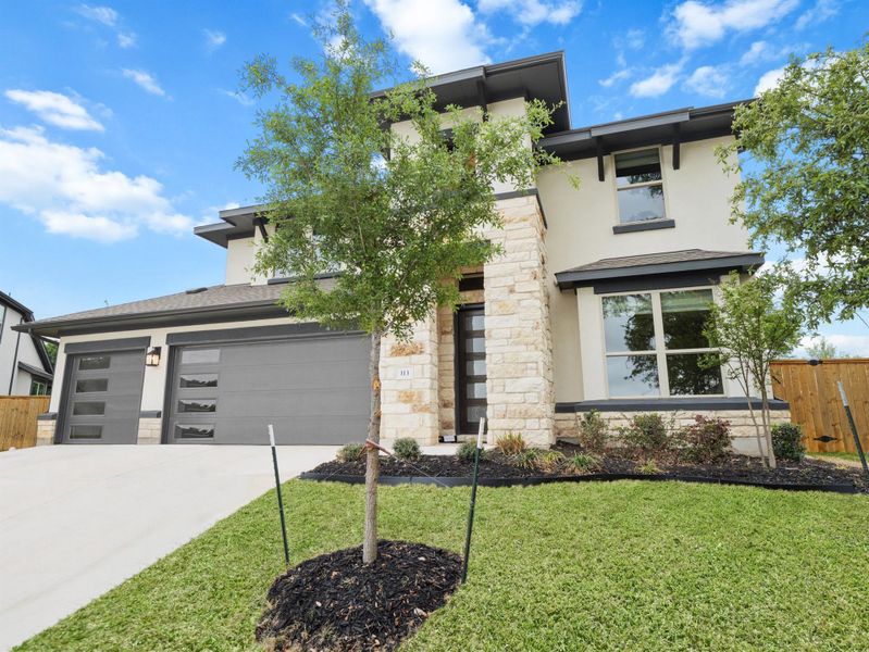 Prairie-style house with stucco siding, stone siding, concrete driveway, and 3 car garage