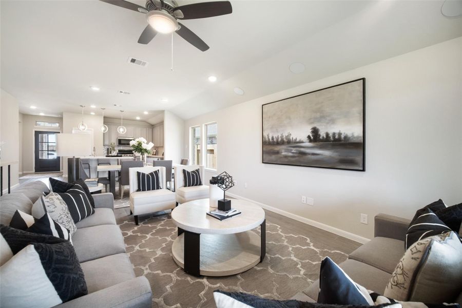 Welcome family and guests to your charming living room! With its high ceilings, recessed lighting, ceiling fan, custom paint, beautiful flooring, and large windows that let in abundant natural light, this room is perfect for gatherings. Sample photo of completed home with similar floor plan. Actual colors and selections may vary.