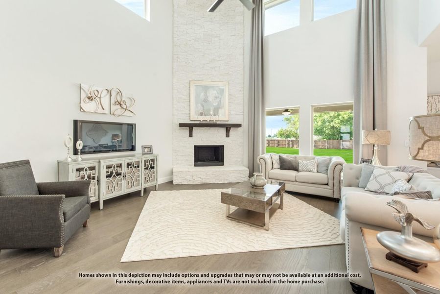 Living room with two-story ceiling, stone fireplace, hardwood floors, and large windows Living room with two-story ceiling, stone fireplace, hardwood floors, and large windows