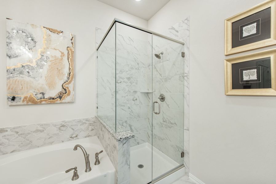 Bathroom with soaking tub, glass-enclosed marble shower, and decorative wall art