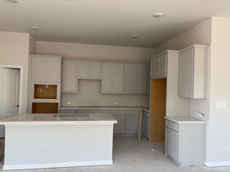 Kitchen featuring a kitchen island and light stone countertops Kitchen featuring a kitchen island and light stone countertops