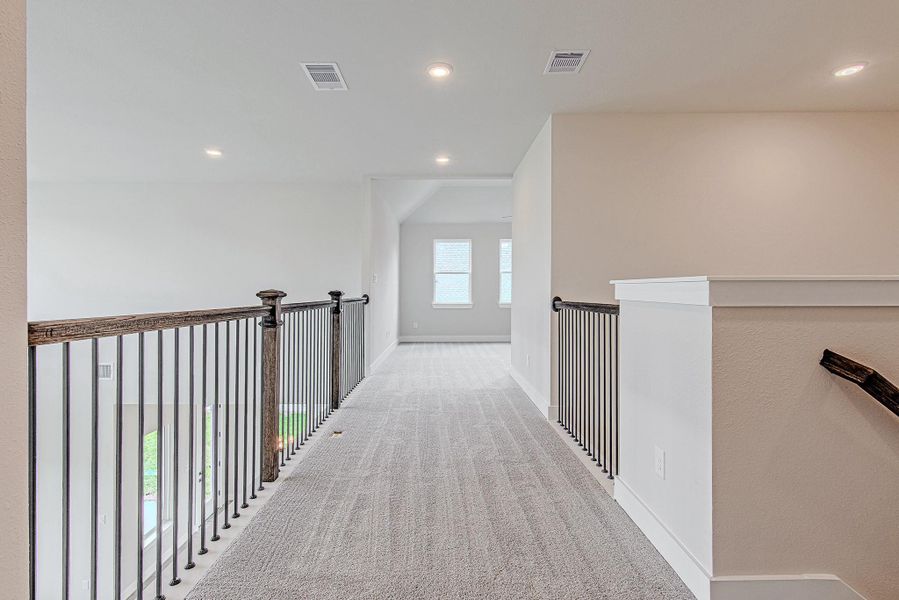 Upstairs hallway with open railing overlooking the main living area.