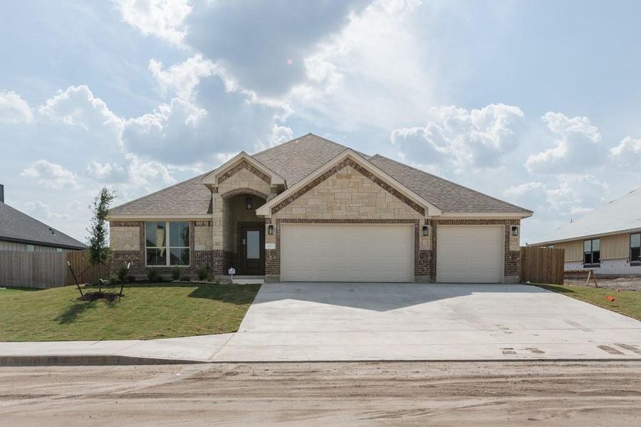View of front of home with stone siding, concrete driveway, brick siding, an attached garage, and a shingled roof View of front of home with stone siding, concrete driveway, brick siding, an attached garage, and a shingled roof