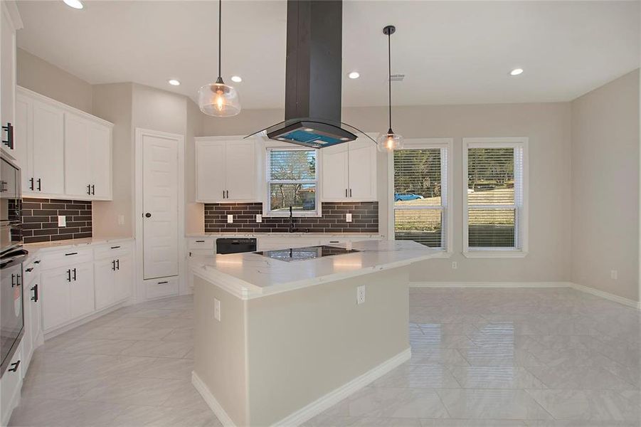 Kitchen with ventilation hood, pendant lighting, backsplash, light stone counters, and recessed lighting Kitchen with ventilation hood, pendant lighting, backsplash, light stone counters, and recessed lighting
