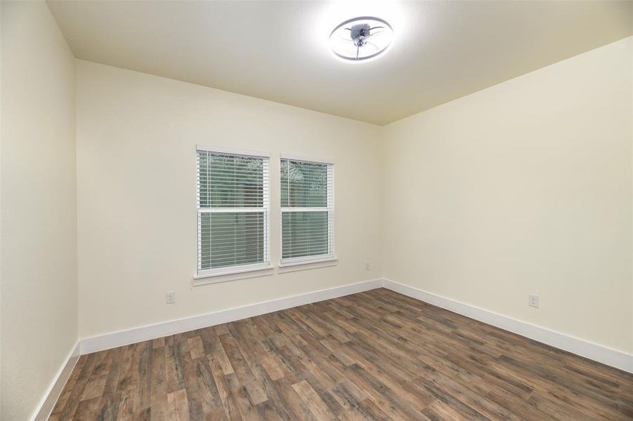 2nd  bedroom split from primary with 2 inch blinds and ceiling fan.